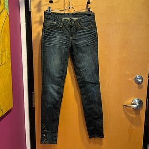 Dark wash skinny denim jeans, ripped knee and button details